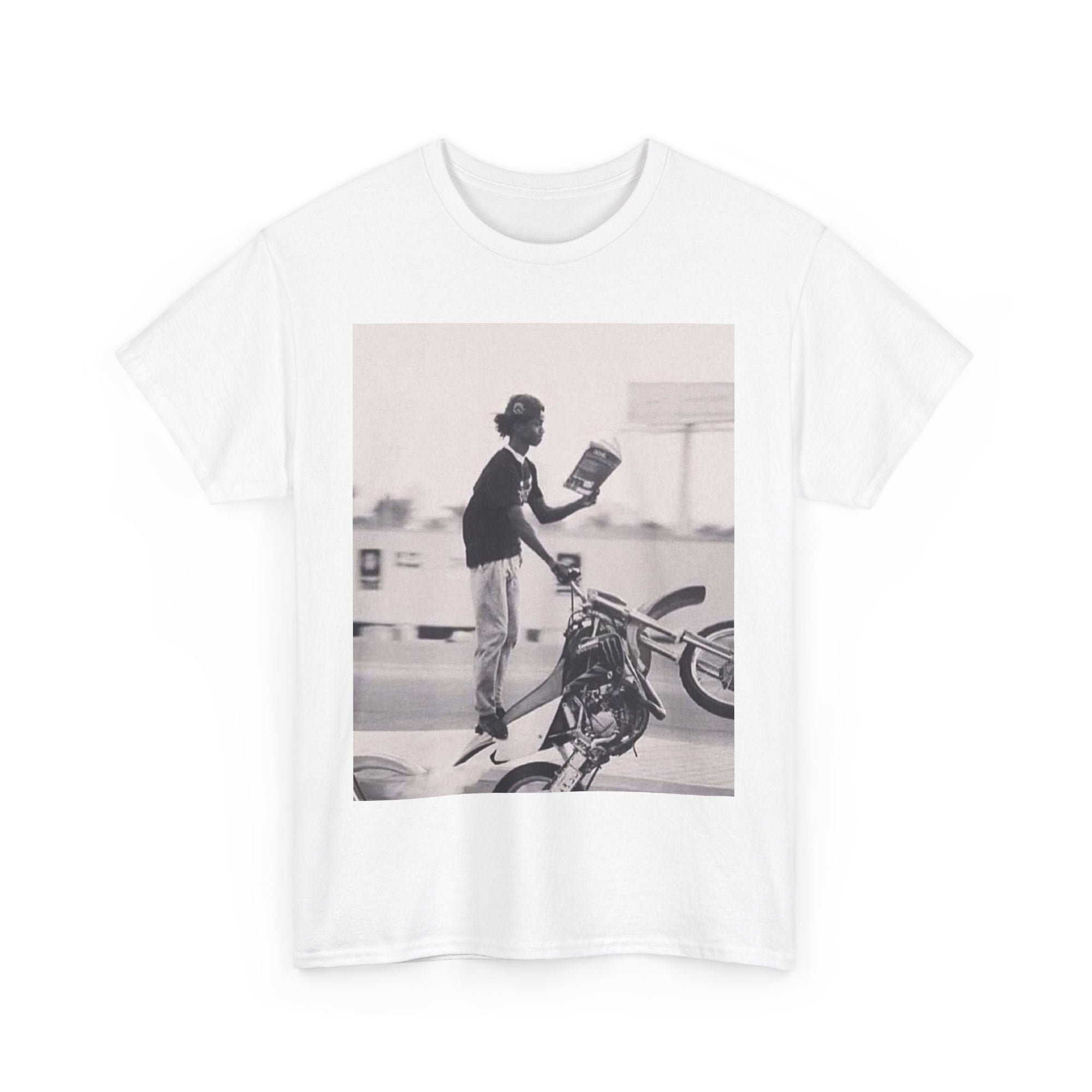 White t-shirt with a graphic of a person on a motorcycle and a book.