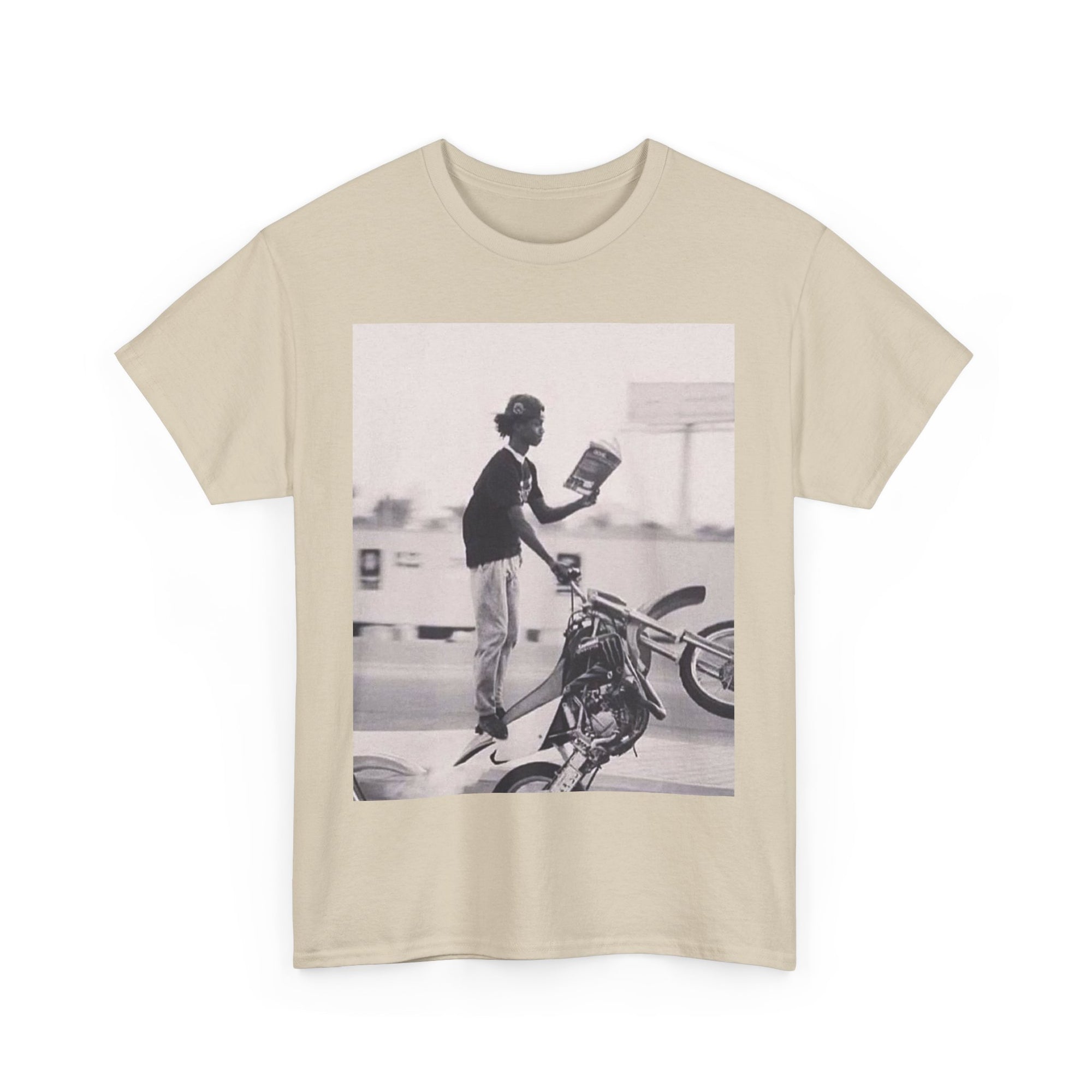 Beige t-shirt with a graphic of a person on a motorcycle and book